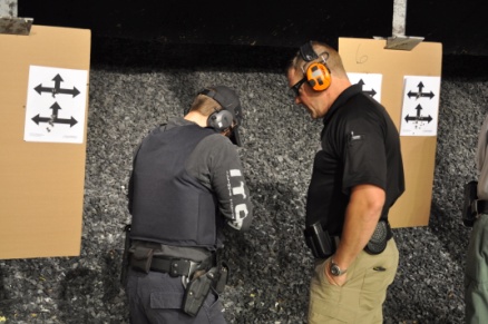 Chris works with a shooter, talking to her while helping her feel the slack and then the pressure wall before the shot.